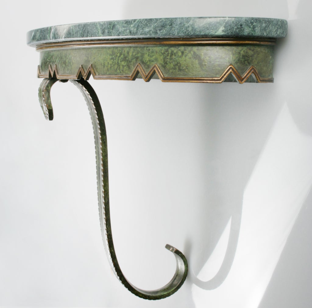 This is a beautifully forged and sculpted bronze console with a verdigris patina. The green marble top is 3/4 