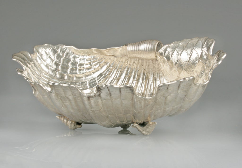 This is an intricately fahioned silver centerpiece bowl. The beautiful shell form sits on three shell 