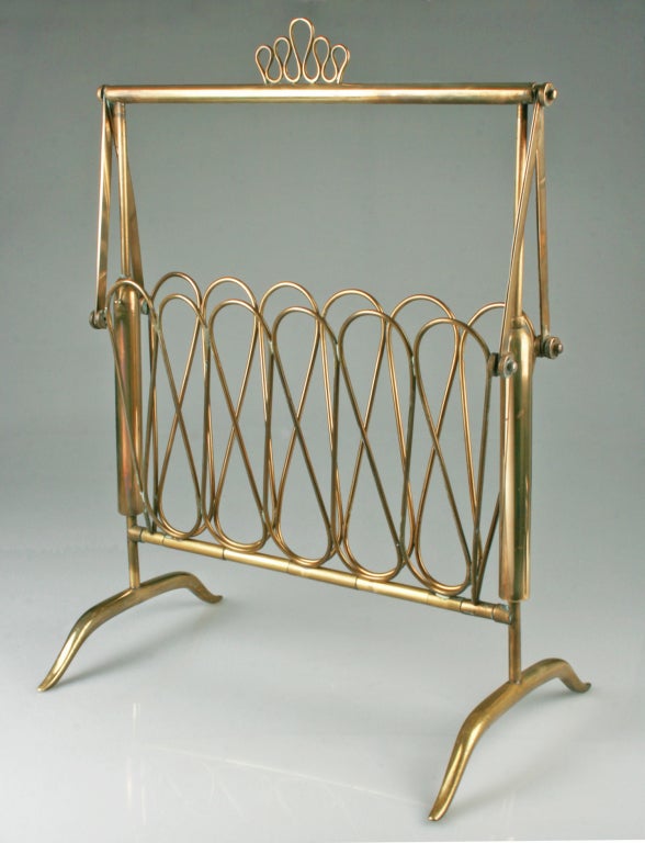 This is a  finely crafted and designed magazine rack that folds up when being lifted or stored away. It looks like Fontana Arte.  In its collapsed state it measures
11 1/2 
