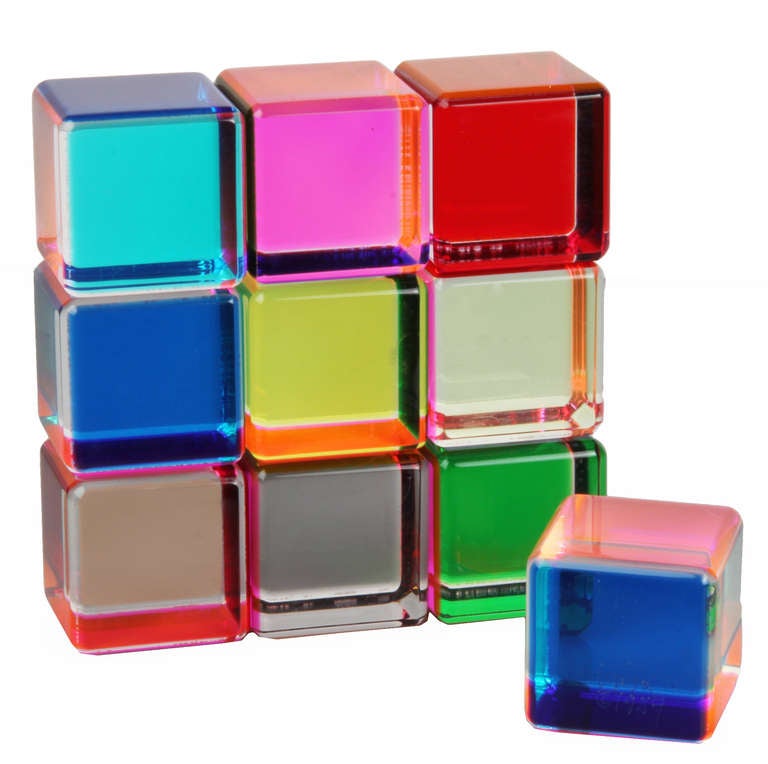 This is an early  group of ten multi colored cast acrylic blocks by Velizar Vasa. One cube is marked Vasa copyright 1984. This is an interactive sculpture that can be assembled in countless color and design combinations.