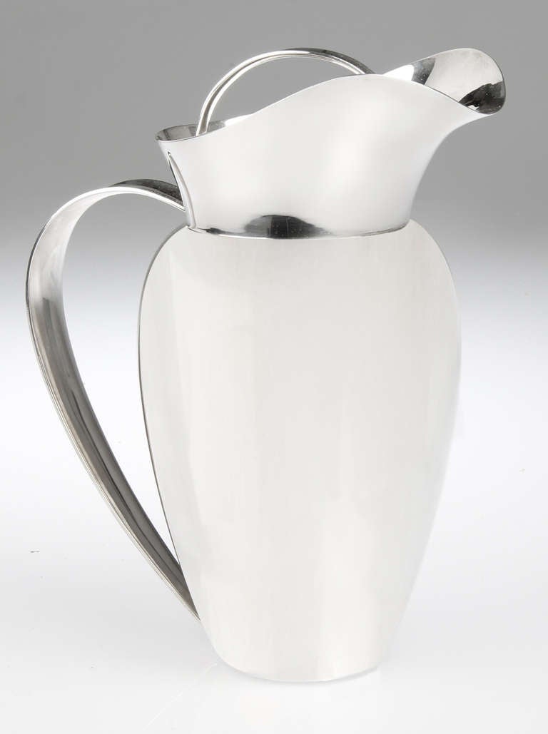 This is an elegant modernist sterling silver lidded pitcher by noted California silversmith Allan Adler.