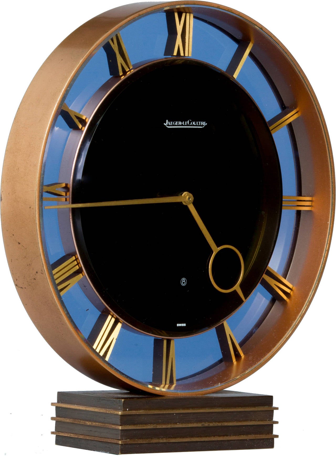 This is a rare clock featuring Art Moderne styling, Roman Numerals, a light  blue  and black glass face and a bronze dore case.
