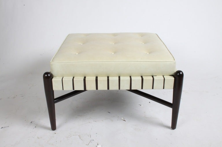 1950s midcentury Ottoman or stool with original crème leatherette straps and cushion, refinished in dark brown espresso on walnut base with X-stretcher supports. Can be reupholstered for additional cost, please inquire. Attributed to Tomlinson