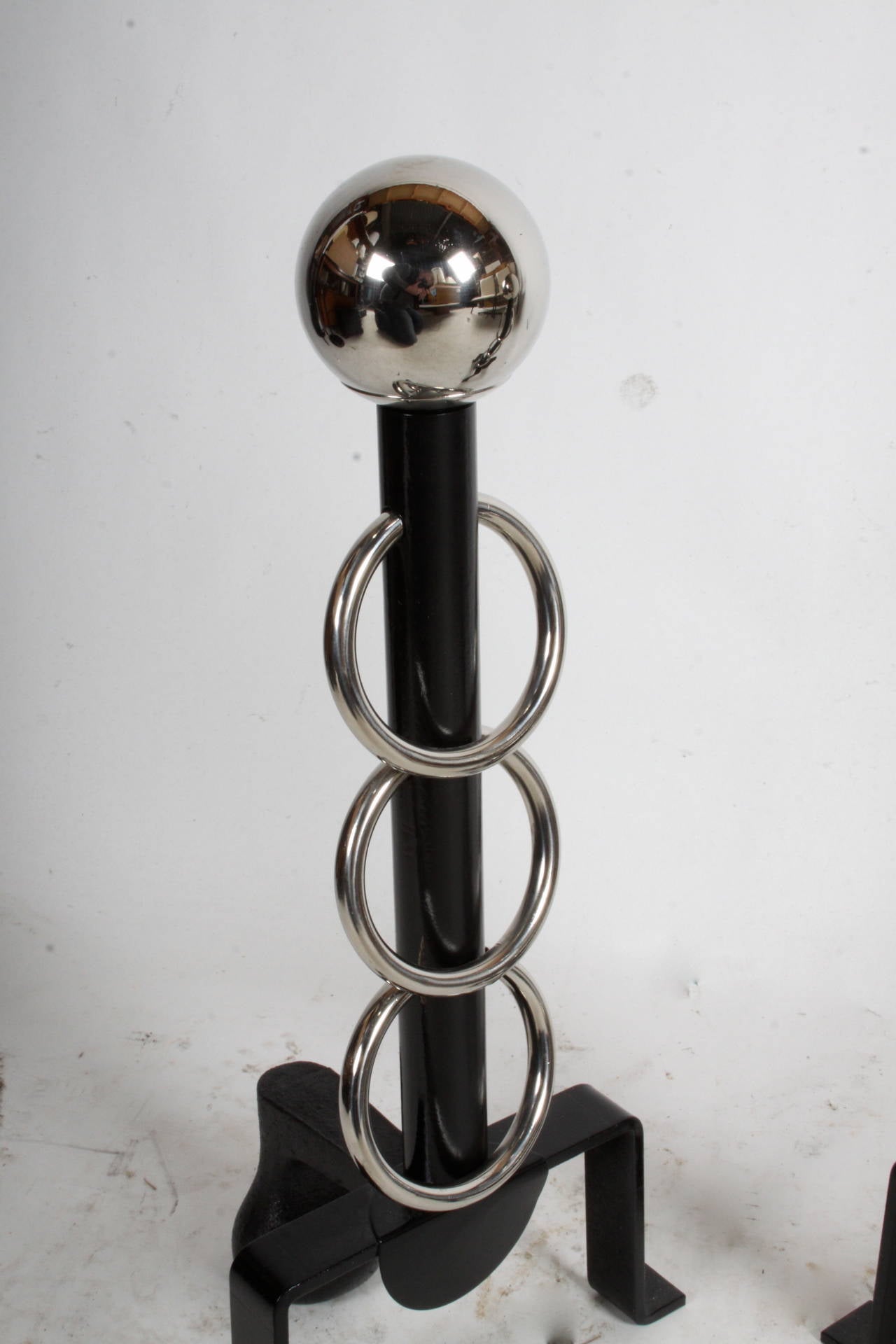 Pair of Midcentury sculptural iron and nickel andirons. Nickel ball finial with nickel ring accents.