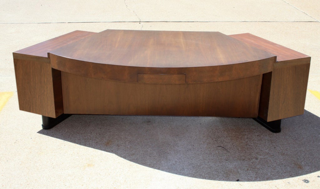 Curved custom desk with two banks of three drawers with stylized X pulls, Center drawers on both sides of top, so can be used as a partner's desk. 70