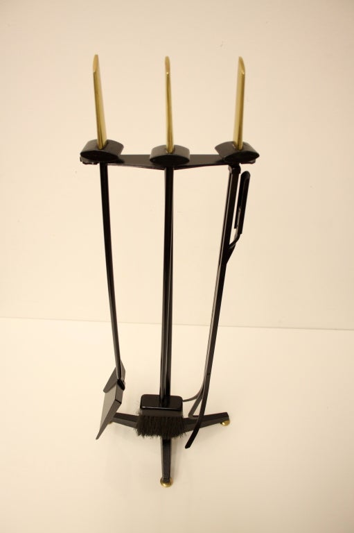 Brass arrow handles with stylized form fireplace tools on tripod stand