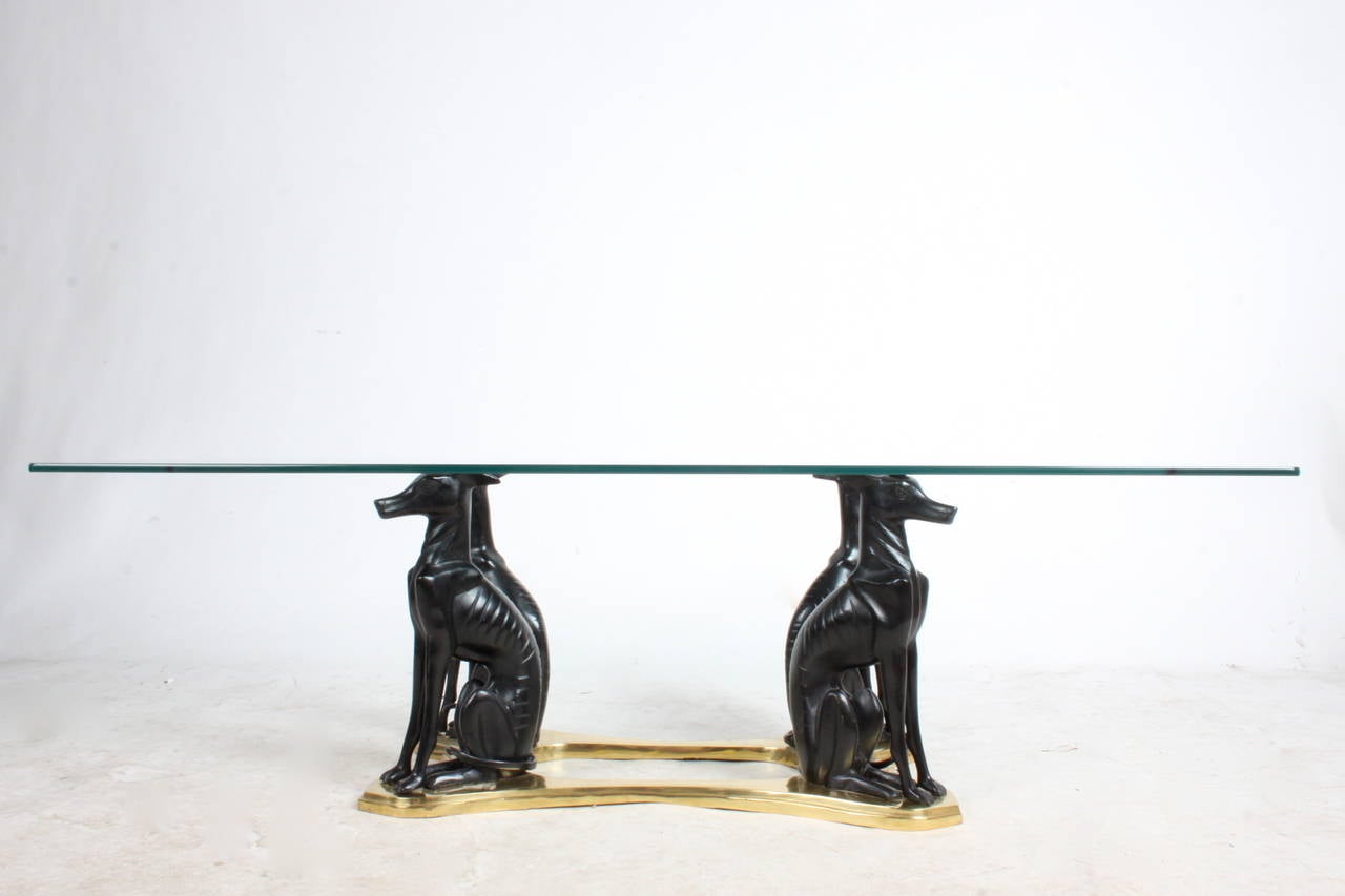 Glass top coffee table with base in brass with four whippet dog forms, base 28.5 x 16 W. 
Glass 3/8.