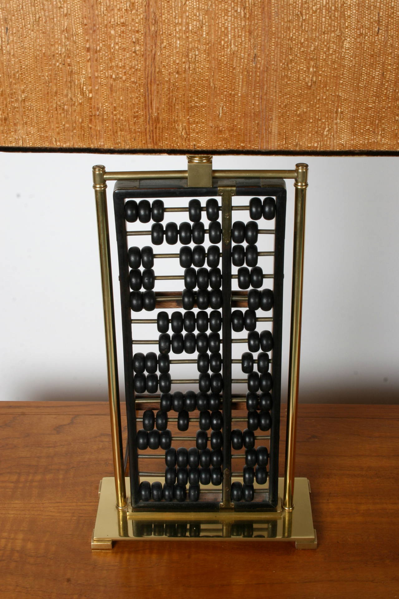 Mid Century Chinese wood abacus lamp with brass frame, lamp shade shown not included. Takes large format bulb, but screw in conversion socket can be added. Has white glass diffuser that holds shade. Newer lamp cord, minor wear to brass.