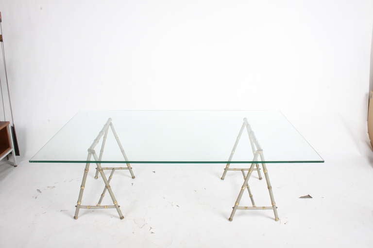 Table basse de style Maison Jansen en laiton et nickel à base de cheval de scie. Le grand plateau en verre mesure 36