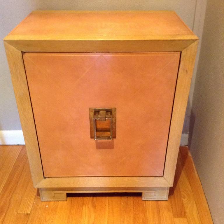 1940s pink leather door cabinet that has in used diamond pattern tooled in 22-karat gold. Top and sides also leather with a bleached mahogany framing and Greek key detail on base.

Reduced price is net 
