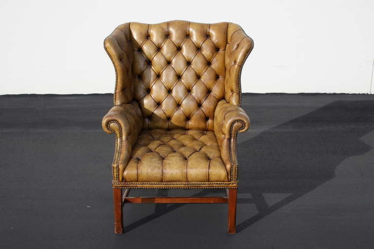 Large English leather tufted wingback armchair, with brass tacks and nice leather patina.