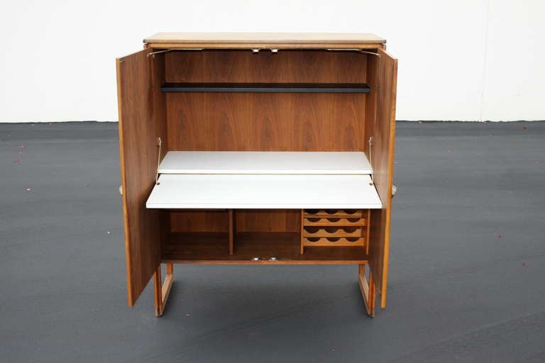 Jens Risom bar cabinet, label, interior with holders for bottles, finished back.
Measures: 55.25 H x 19 D x 44.25
drop shelf 40.25 W x 17 deep and 28.75 from floor
inside white shelf 15.5 x 41.75
black shelf for glasses 7.5 deep.