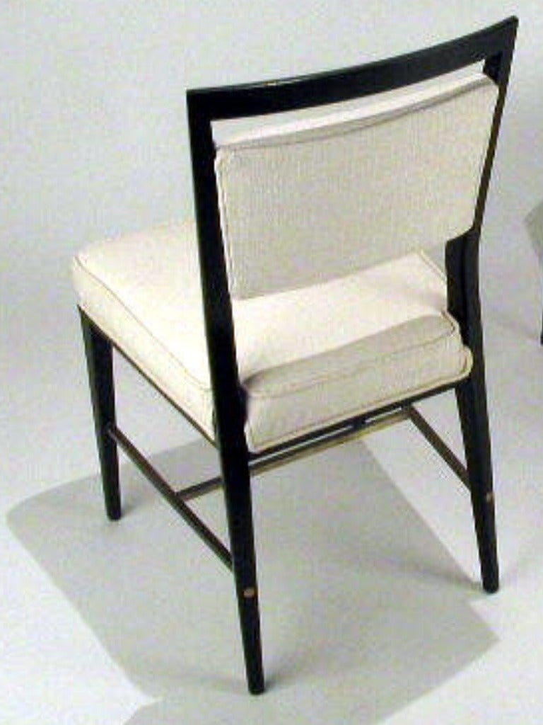 Set of eight McCobb dining chairs with upholstered seats and backs, brass cross stretchers.