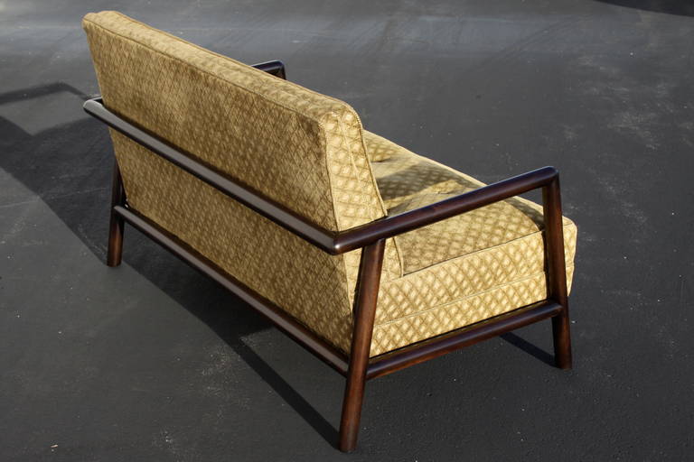 Mid-Century pair of settees with wrap around walnet dowel frames in dark expresso, designed by T.H. Robjohn-Gibbings for Widdicomb in the early 1950s. Frames have been refinished, older upholstery. 