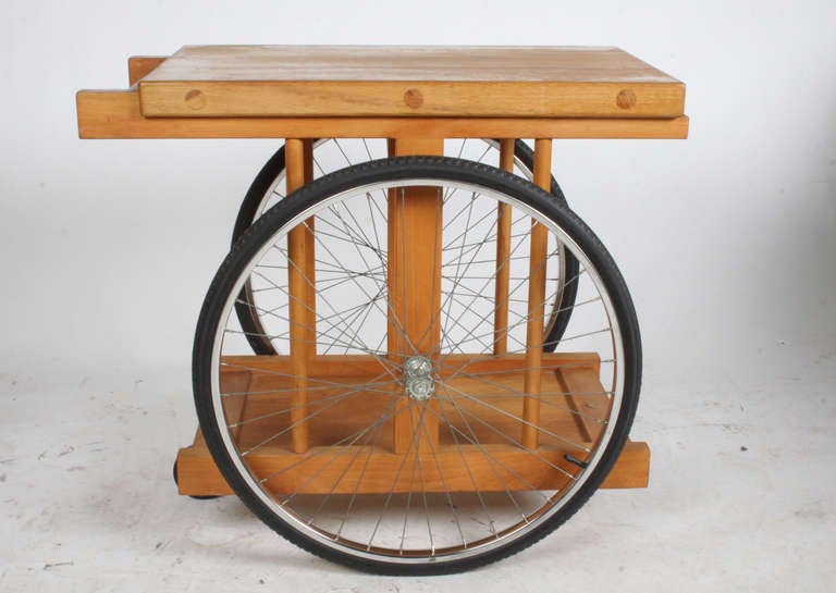 Bar cart with bicycle wheels by artist Bill W. Saunders. Designed by artist Bill W. Saunders as part of his California design series that was shown at the Pasedena Art Museum. Designed 1964 gh 33.75” L x top is 21” W x 29.5” H Literature: California