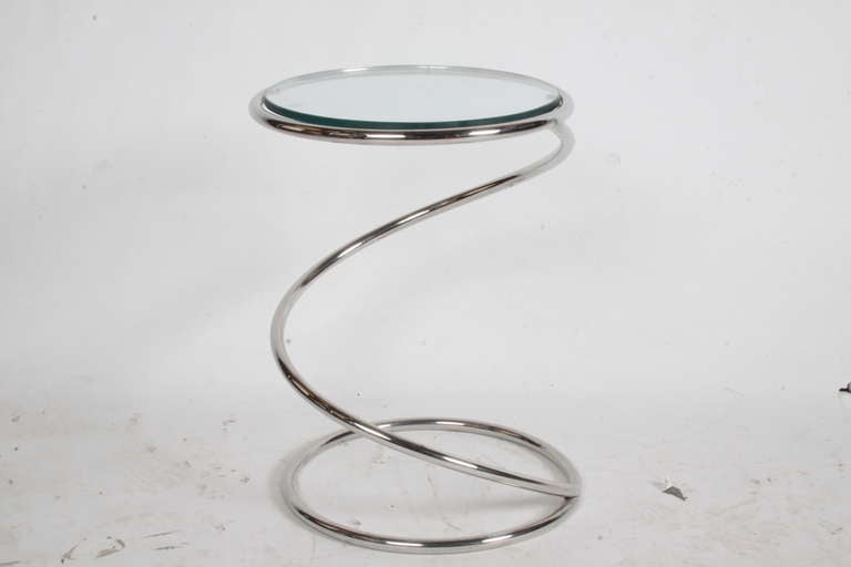 Chrome side table in sculptural form with glass top.