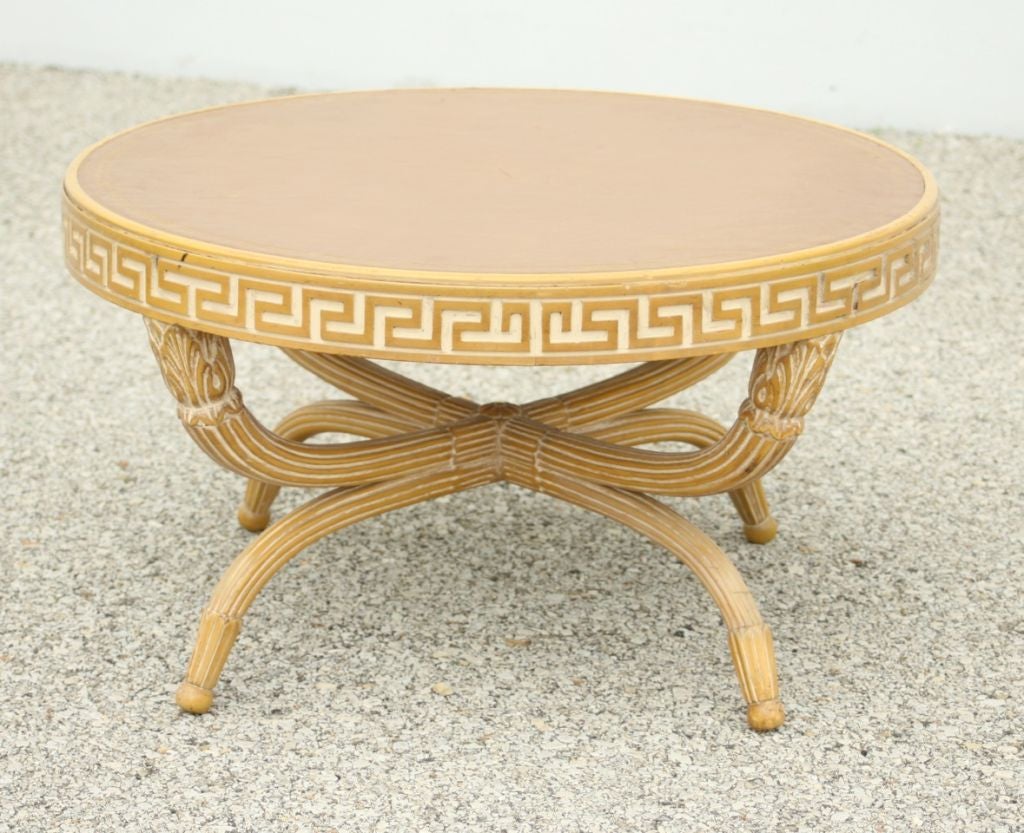 Cocktail table in the style of T. H. Robsjohn-Gibbings early work or Grosfeld House, Greek key banding around top with carved fluted legs and leather top. In the style of Baker Furniture.