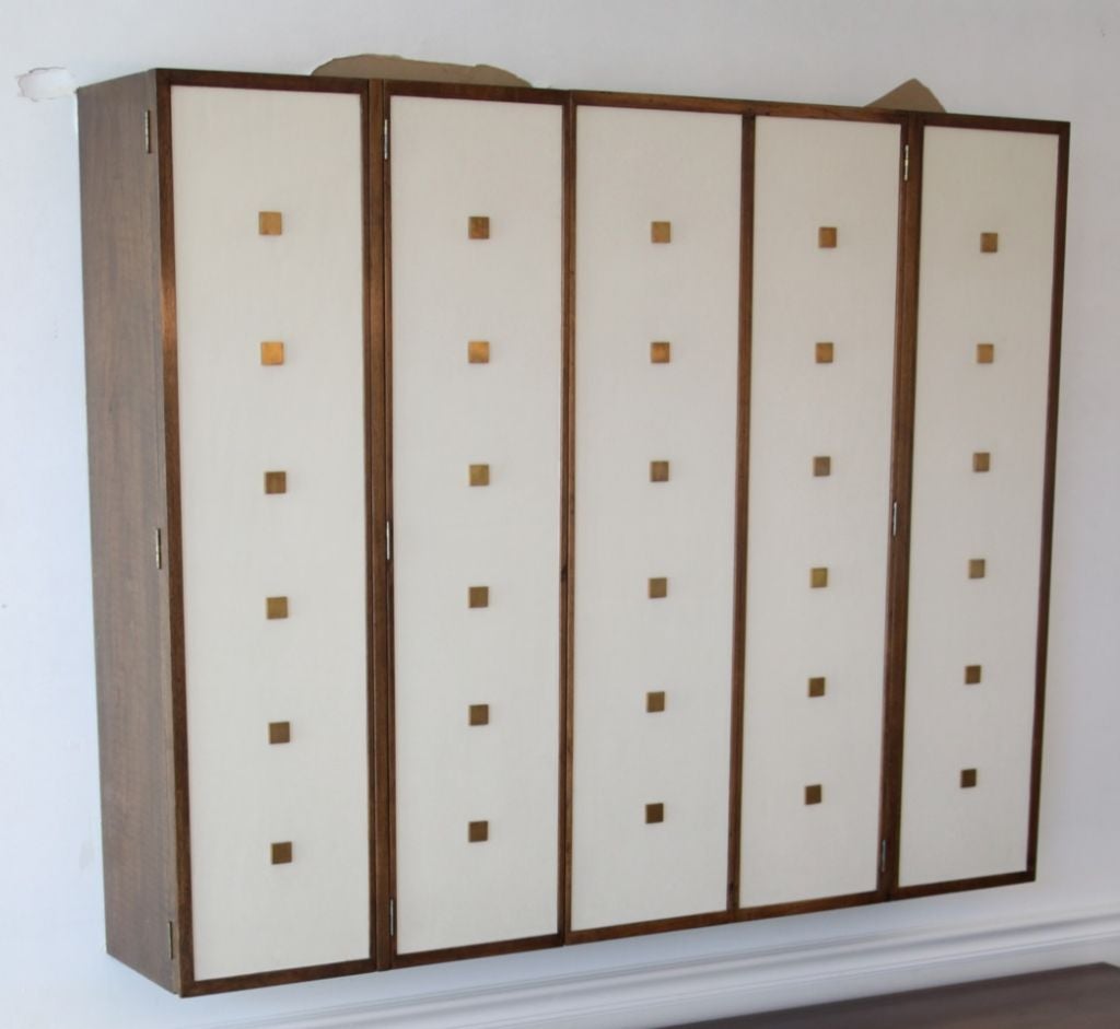 Bert England for Johnson furniture wall-mounted cabinet, leather covered doors with brass stud hardware.