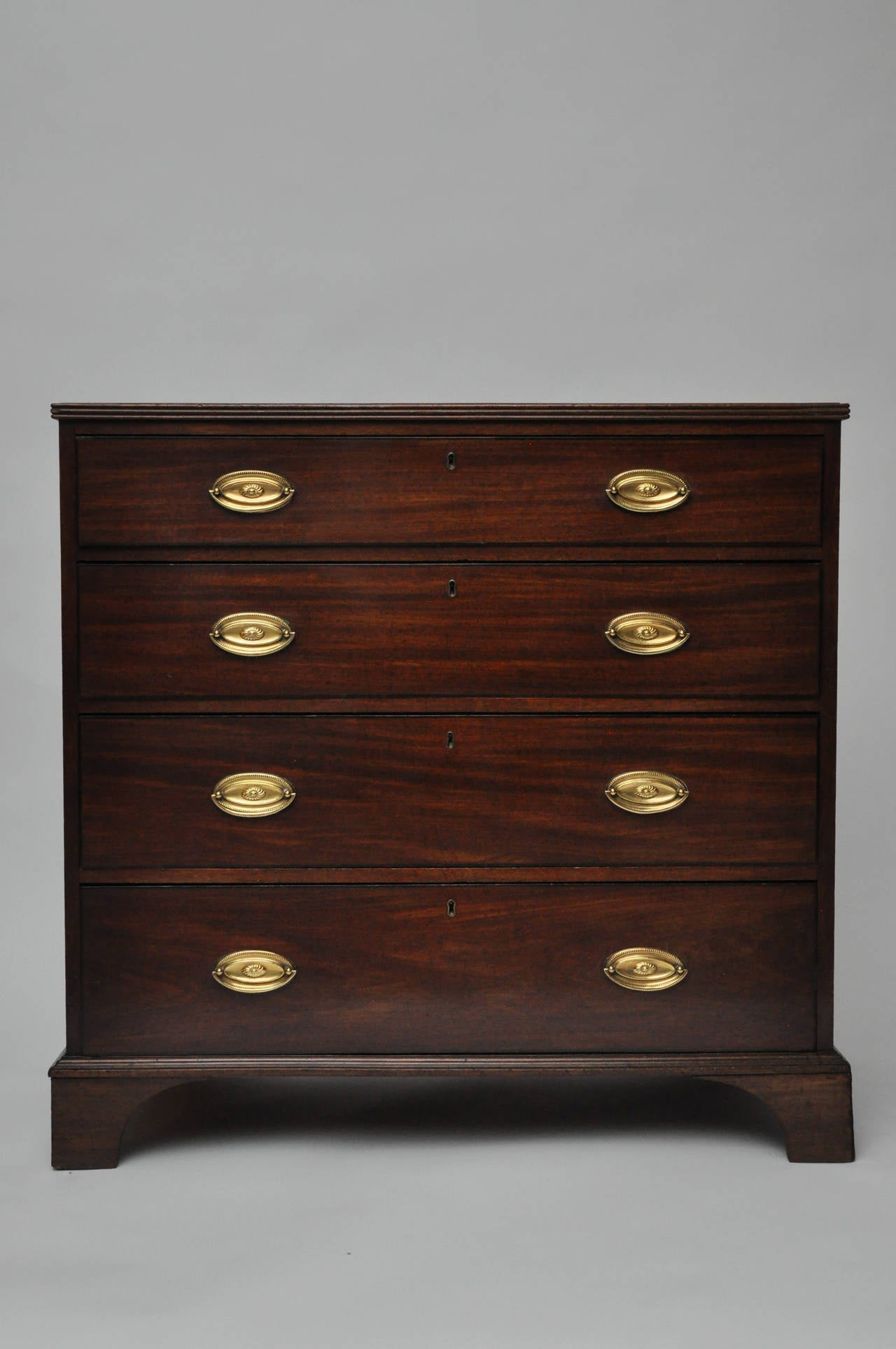 Early 19th century George III mahogany chest of drawers with applied, reeded molding to top and four graduated ebonized draw-front drawers with trim.