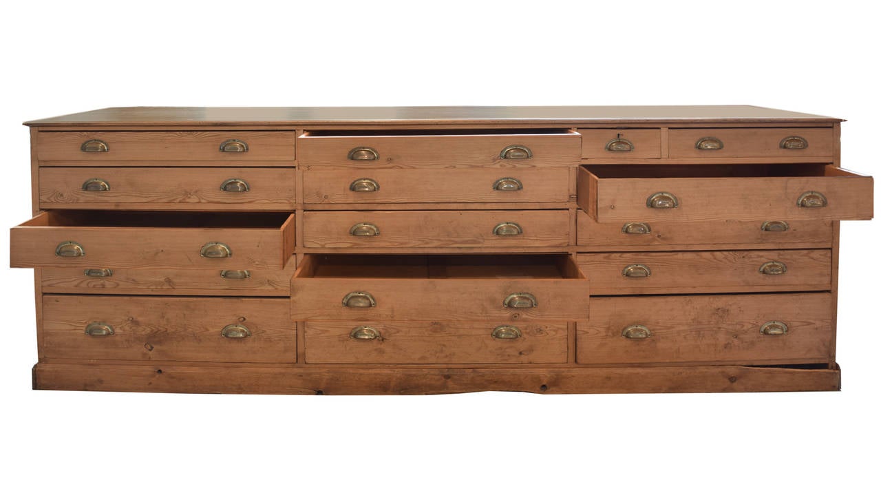 Wood counter from a Chicago retail store, finished on all sides, with 15 drawers with brass hardware. Circa 1890.