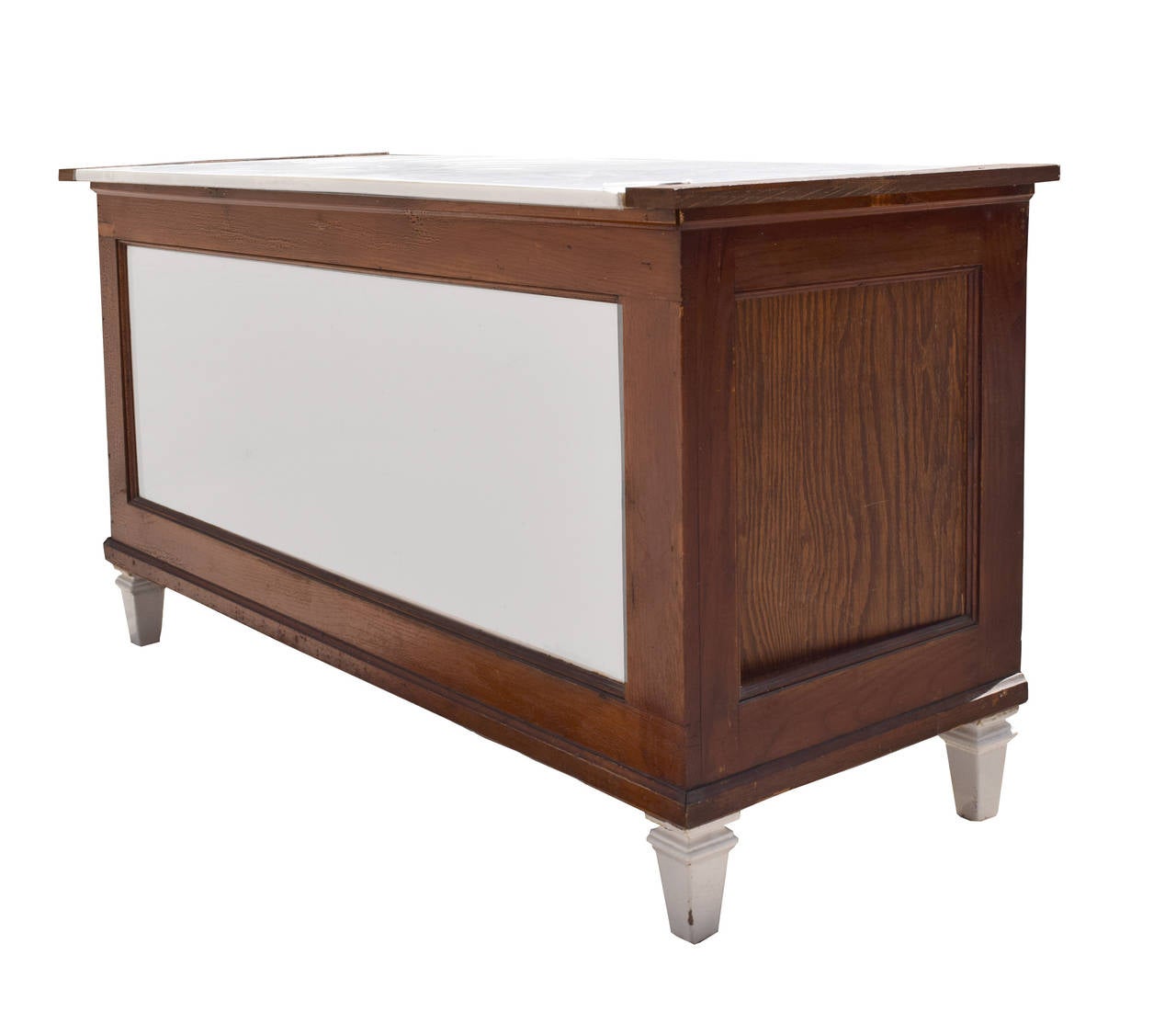 Early 20th century American wood counter with a vitrolite glass top and front panel, resting on four porcelain over iron legs.
   