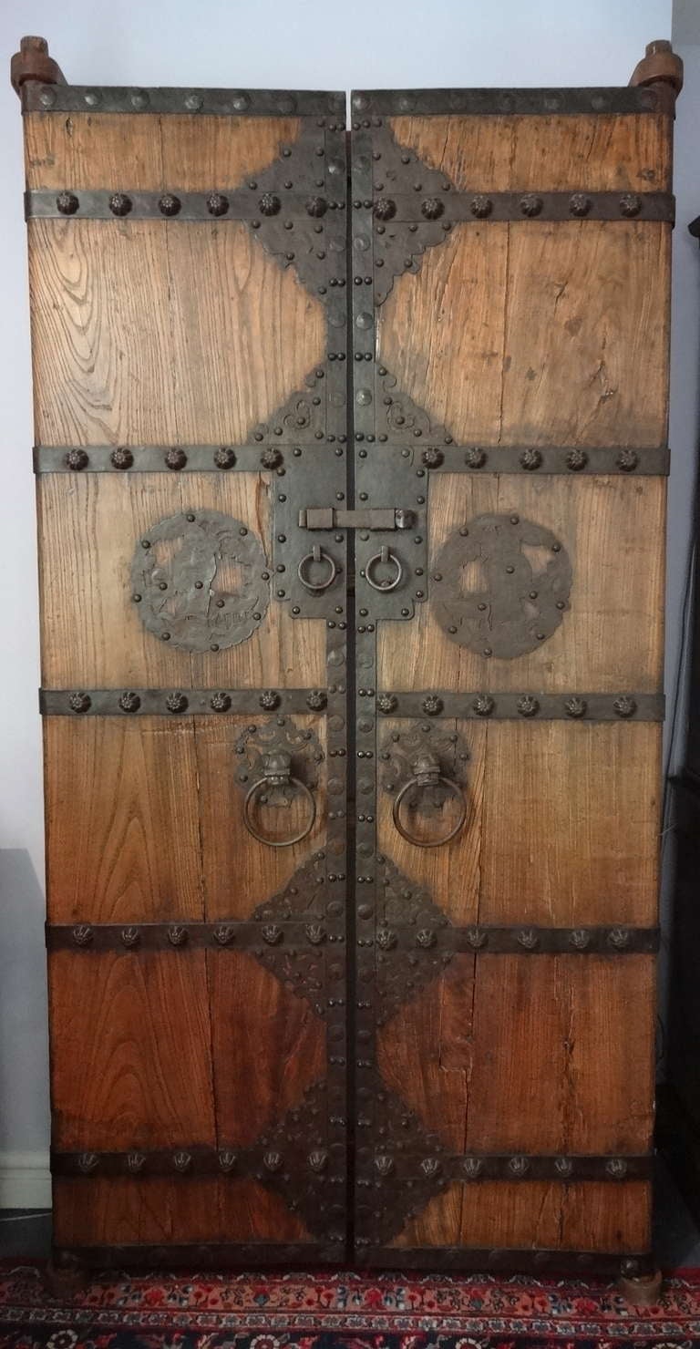 This pair of Chinese Garden Gate Doors also has a pair of stands to hang these doors on the wall.  Hand made Doors with embelishments of iron made in the 1750-1760.  Note the dog heads with rings in their monuths as handles.  Large decorative studs