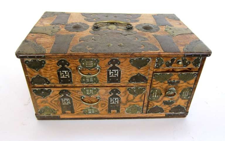 This Chinese Box is hand made having 4 drawers, 2 over 2.  The wood is emblished with brass design pieces, chinese symbols, flowers and handles to the top having a BAT under the handle for good luck and long life