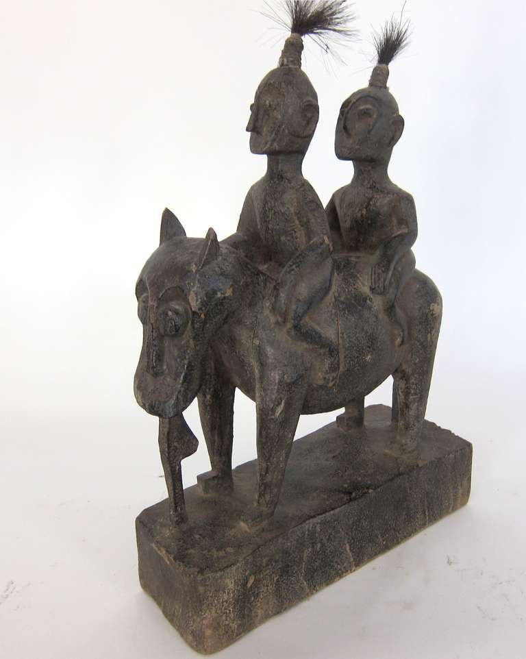 Finely crafted hand carved Sumatran wooden statue of 2 men on horseback with both riders having top “spray” of hair. Provenance: a prominent Singaporean collector.