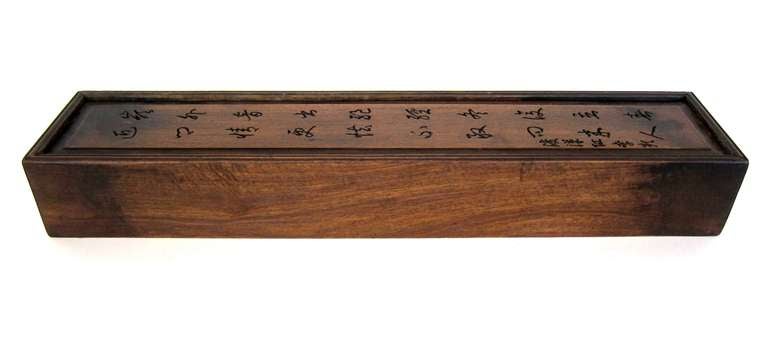 This Chinese scholar's scroll box crafted from sought after Haunghauli Wood. The sliding lid is decorated with a carved Chinese poem. This scroll box was used to house prized scrolled artwork.