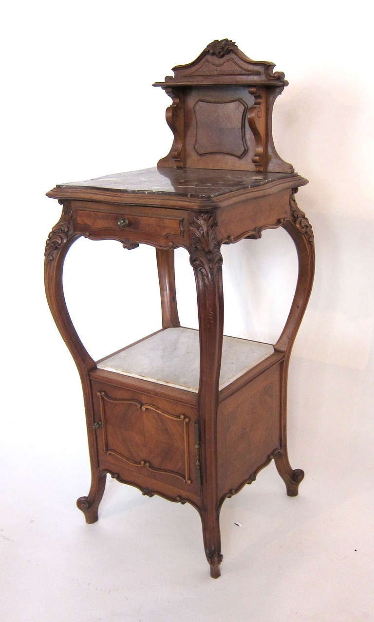 An exquisitely carved French night stand in Cherry wood. Has a draw on top and cabinet space under a shelf. The top and middle shelf is finished with marble.  Hand Made Top measures 32