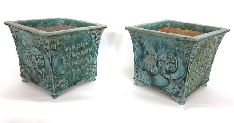 A pair of Chinese planters highly decorated with low relief bird motifs and Chinese calligraphy designs. The planters have a beautiful Green / Turquoise glaze.