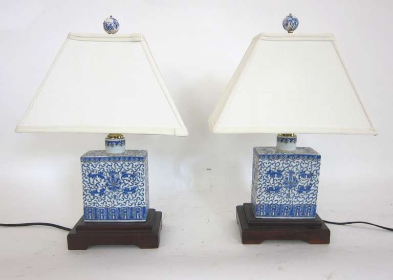 A painted pair of Blue and White porcelain tea container lamps with shades from the early 20th century. The floral design is very well crafted.