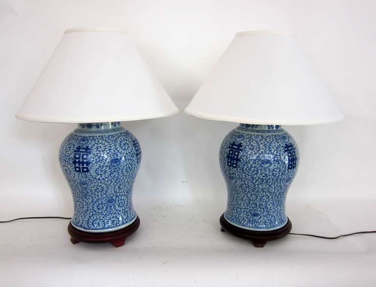 A tall, well painted pair of Blue and White porcelain lamps with the double happiness symbol and delicate floral motif. In the 