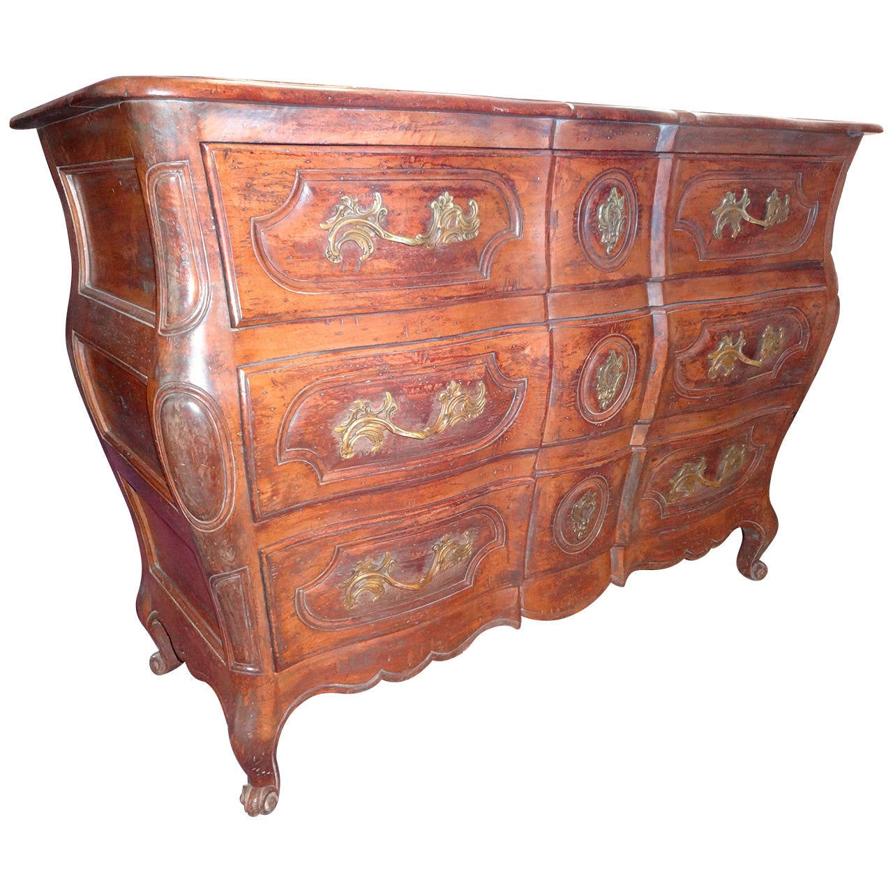 A French provincial walnut bombe commode with bronze pulls. The chest has three drawers.