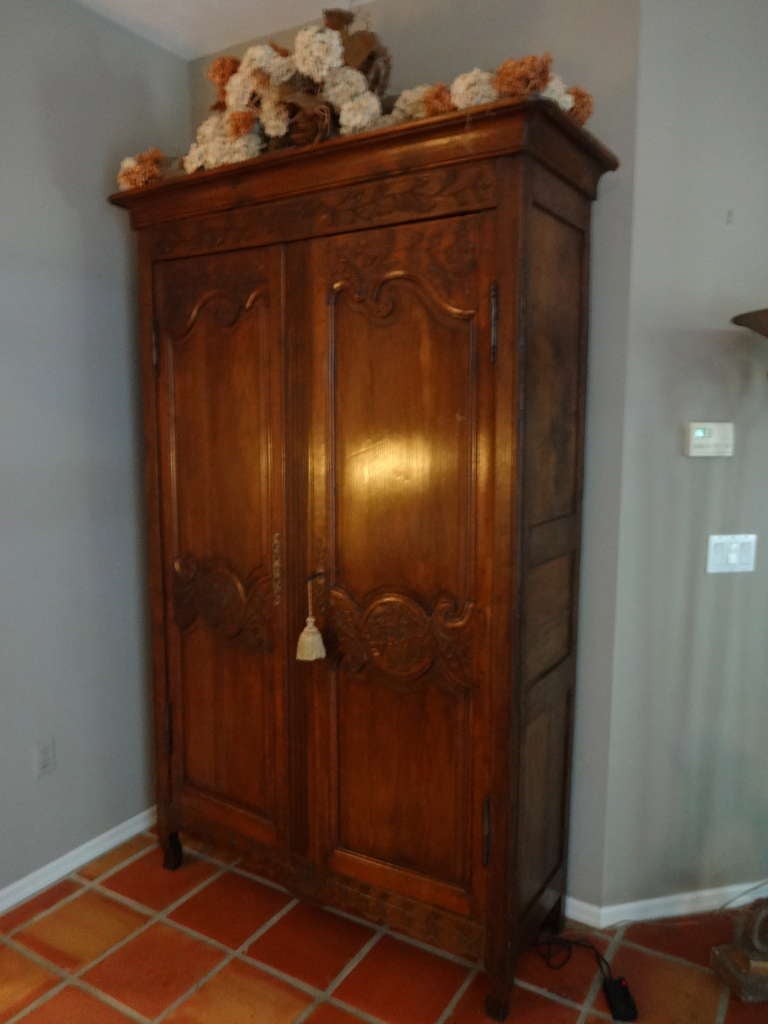 This Beautiful Early 19th Century Oak French Armoire is FITTED inside with upholstery on the shelves, drawer and doors. Hand carved and made with a basket to the top and  flowers to the bottom freeze. Flat cornice (removable), original iron hardware