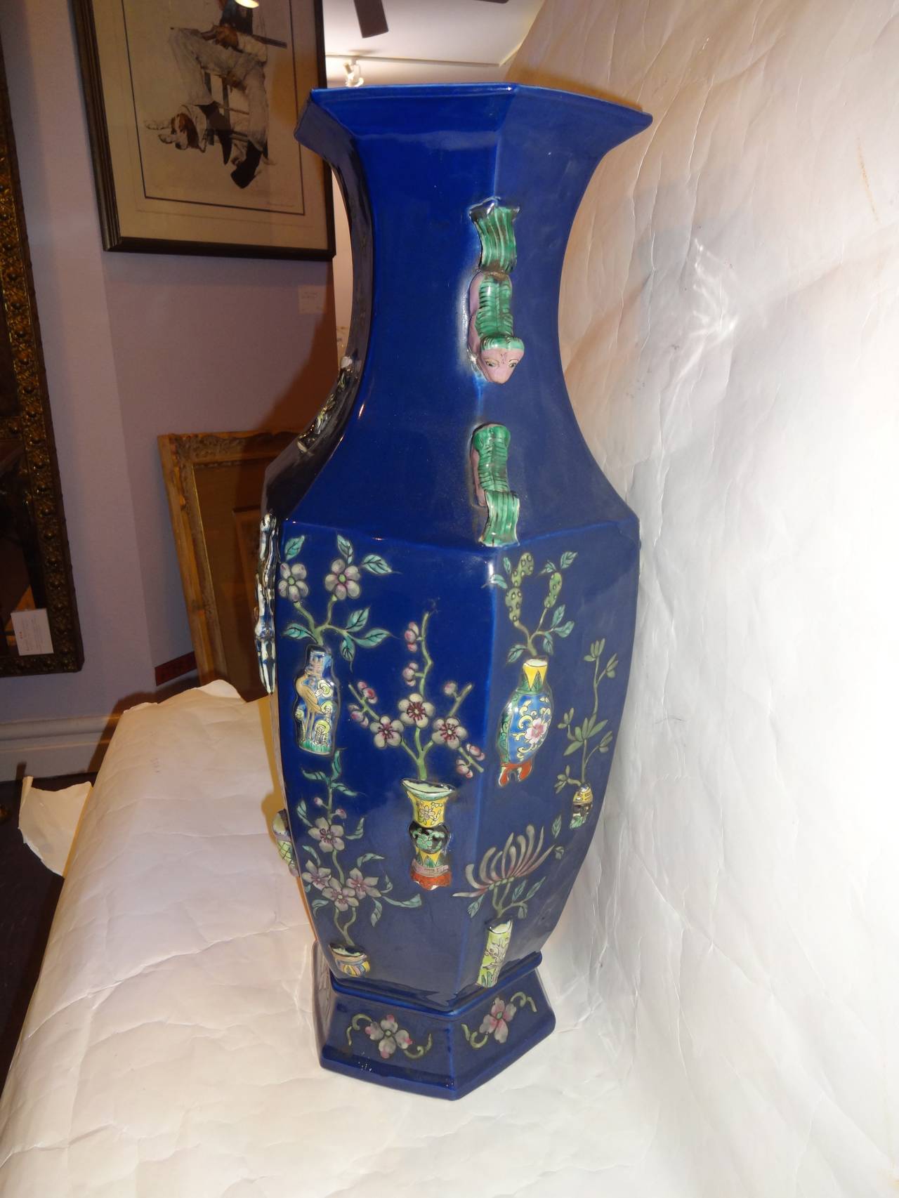 A pair of Chinese dark blue hexagonal shaped vases with foo dog handles, raised relief hand painted decoration, Qianlong seal chop mark on bottom.