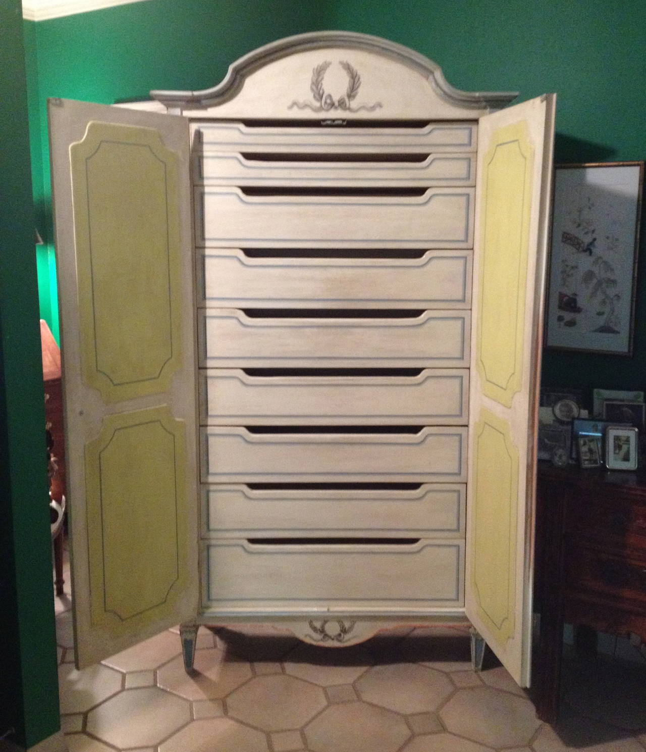 Niccolini custom hand-painted armoire with two recessed paneled doors, nine interior drawers, painted cream with accents of turquoise, yellow and orange.