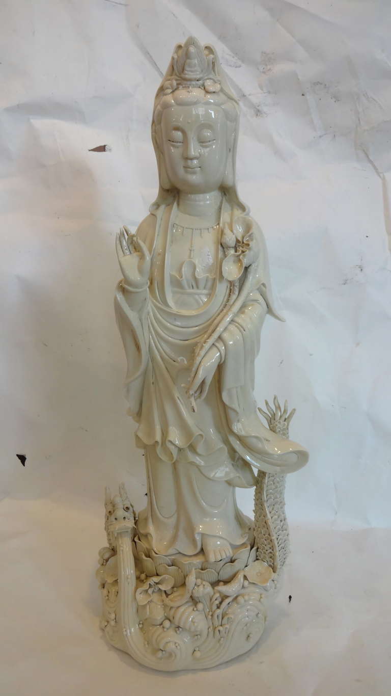 A Blanc de Chine standing statue Guan Yin having a dragon at her feet, waves of water. This piece has a presentation box.