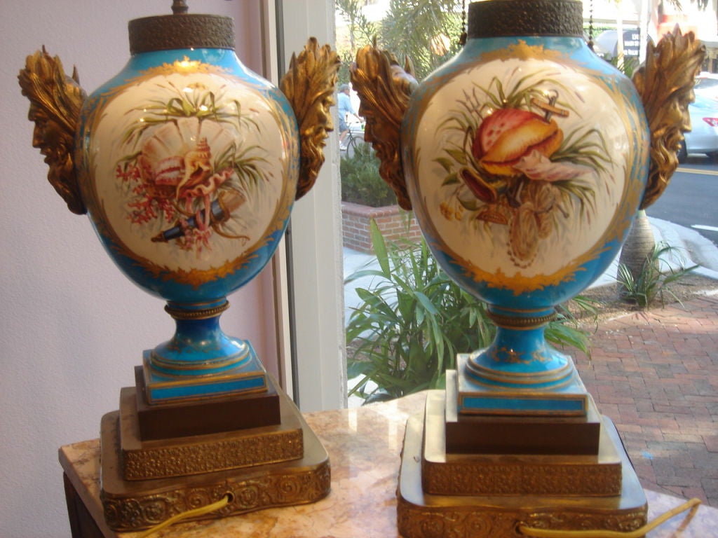 Pair of exceptional French Sevres style Samson lamps, hand painted and decorated, Catherine the Great Blue, Gilt bronze Neptune Heads to each side of each lamp, male cameo design shows shells design and female cameo side shows cupids and women at