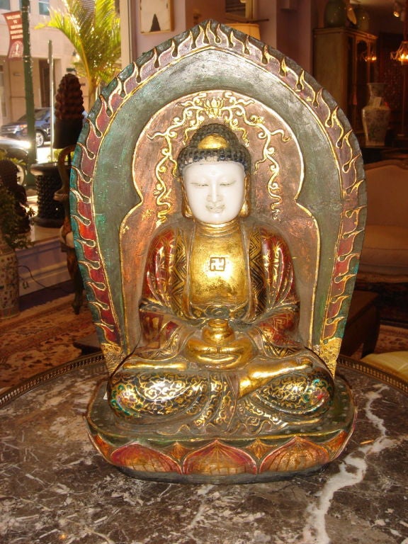 Rare Chinese Gilt & Polychrome Marble Votive Statue of Buddha, hand carved marble from one piece depecting a sitting Buddha figure on a lotus blossom base wearing a brocade robe holding an offering jar hands clasped and framed surrounded by a