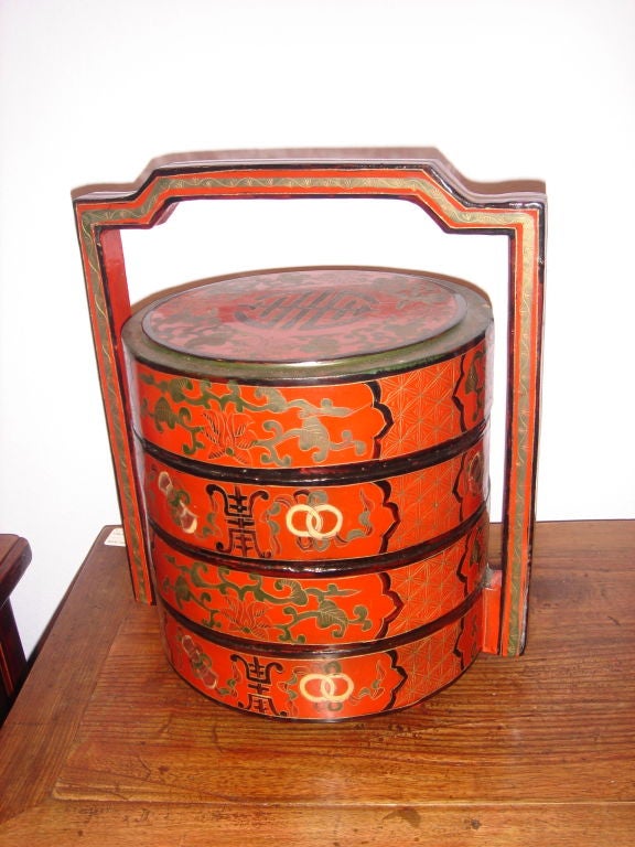 A Chinese Stacking Lacquered Food Container Box, red, black & green lacquer design with gold leaf presented as a wedding gift (note the double rings) very well done containing three sections for food and a lid all hand painted in lacquered colors