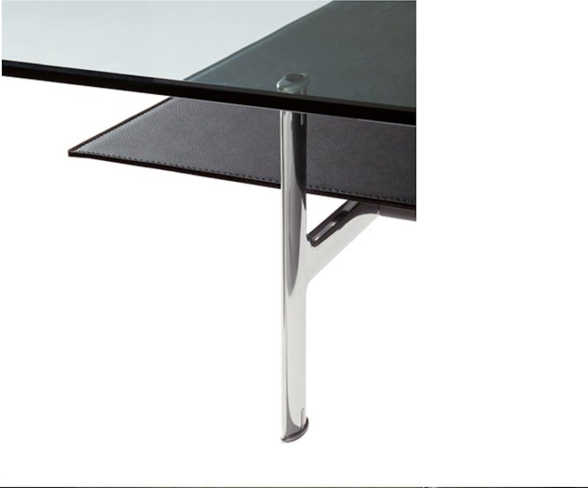 Coffee table by Antonio Citterio 1979 with transparent beveled glass top and underlying shelf in hand-stitched black leather.
The frame is bright brushed and matte aluminum.