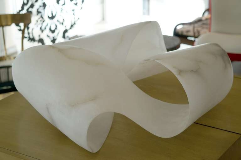 An extraordinary piece, based on a Mobius strip, which has one edge and one surface. The alabaster, from Volterra, Tuscany, is stunning, both in scale and translucency. Carved from a single block of alabaster, resulting in a 60 pound free flowing