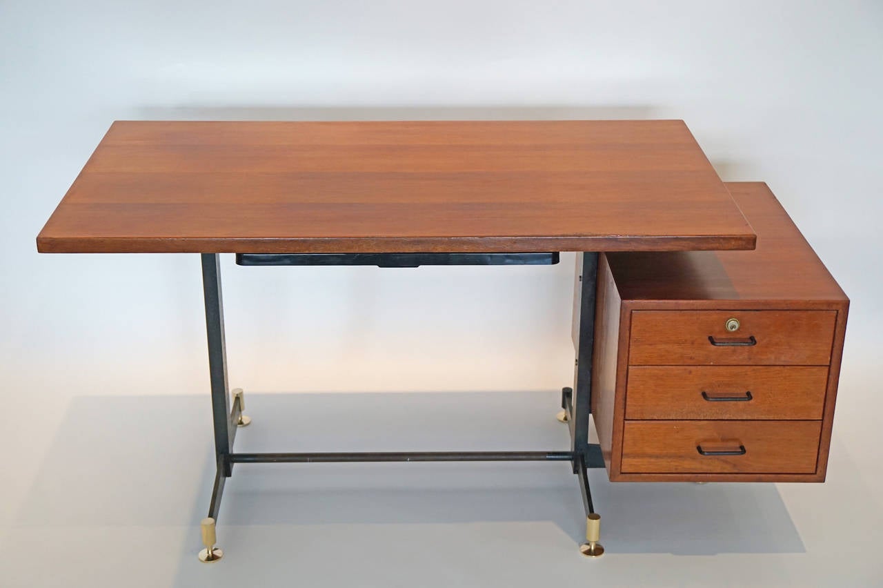 Italian walnut desk by Osvaldo Borsani for Tecno. A single perspex pencil drawer and floating attached case with drawers attached to cast steel footed legs with brass feet. The top and case have been cleaned and oiled; the steel parts retain a