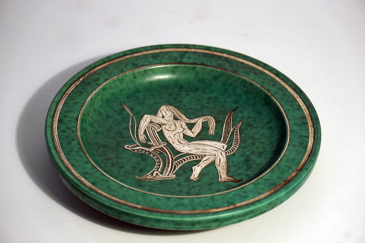 Wilhelm Kage argenta series "nude goddess" plate for Gustavsberg.

Though best known as one of Sweden's greatest ceramists, Wilhelm Kåge (1889-1960) began as a painter, studying in Paris under Henri Matisse. When he returned to