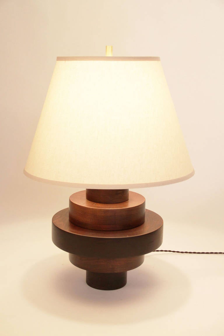 Solid walnut discs, "vandyke brown satin finish." Solid brass finial with full range dimmable socket and silk twist cord. Shade NIC.

Savoie McCormick for Dana John
Lead time: Approximately nine weeks.