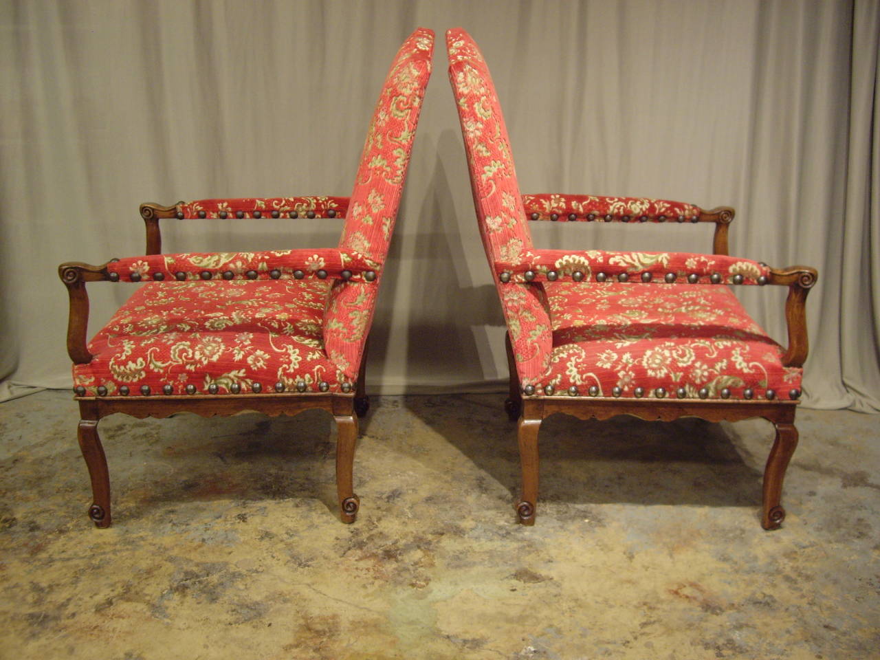Elegant pair of Provincial French Regence armchairs. Delicate carving and graceful proportions. The chairs have been carefully restored and French polished. Arm height is 26.50. The chairs are transitional in the period between Regence and Louis XV.