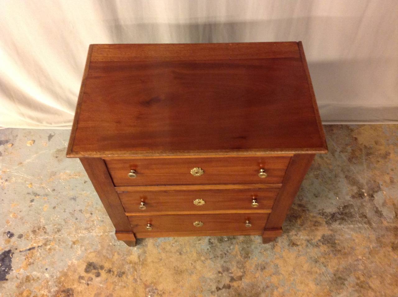 Three-drawer petite mahogany 19th century Directoire style commode.