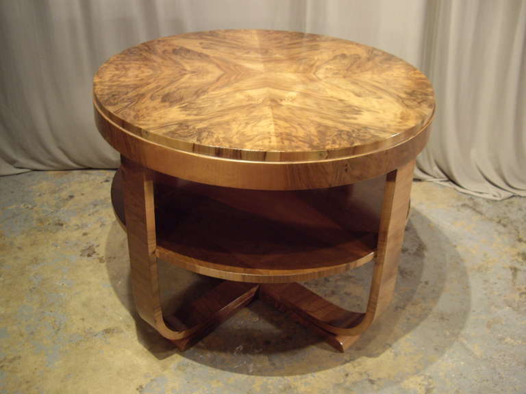 Beautiful walnut Art Deco round table with ribbed legs and shelf. Intricate cut and applied veneers.