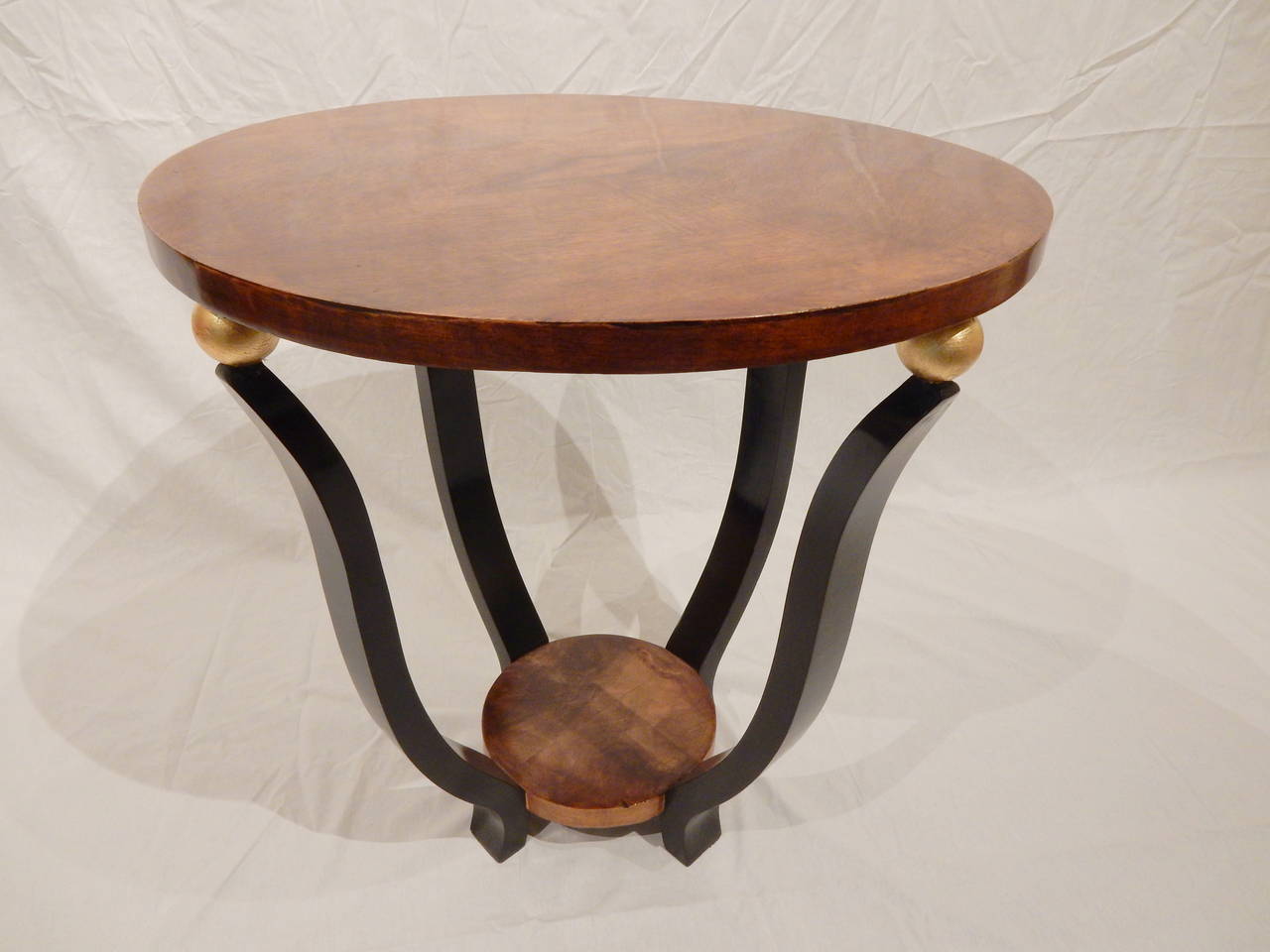 Art Deco round table with black painted table ribs and gilt balls holding a beautiful walnut top. Carefully restored.